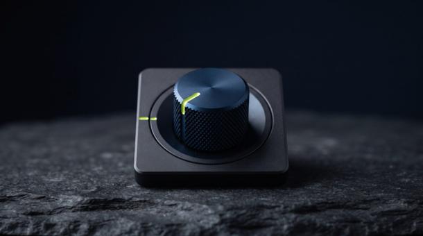 A knurled navy control dial set into a dark panel, its index marker a single chartreuse line.