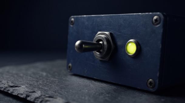 A heavy toggle switch on a navy panel, thrown to one side, a chartreuse indicator lit beside it.