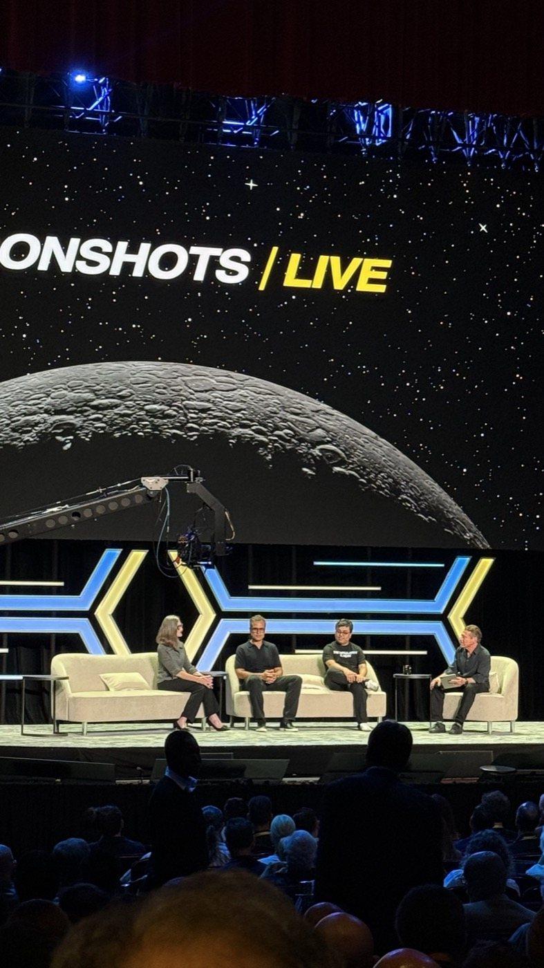 A four-person panel on the United Theater stage under the Moonshots Live screen.