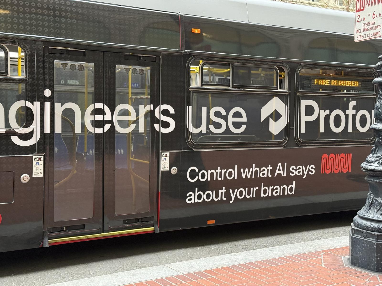 A Muni bus wrapped by Profound passes through downtown San Francisco, 16 September 2026, reading "Control what AI says about your brand".