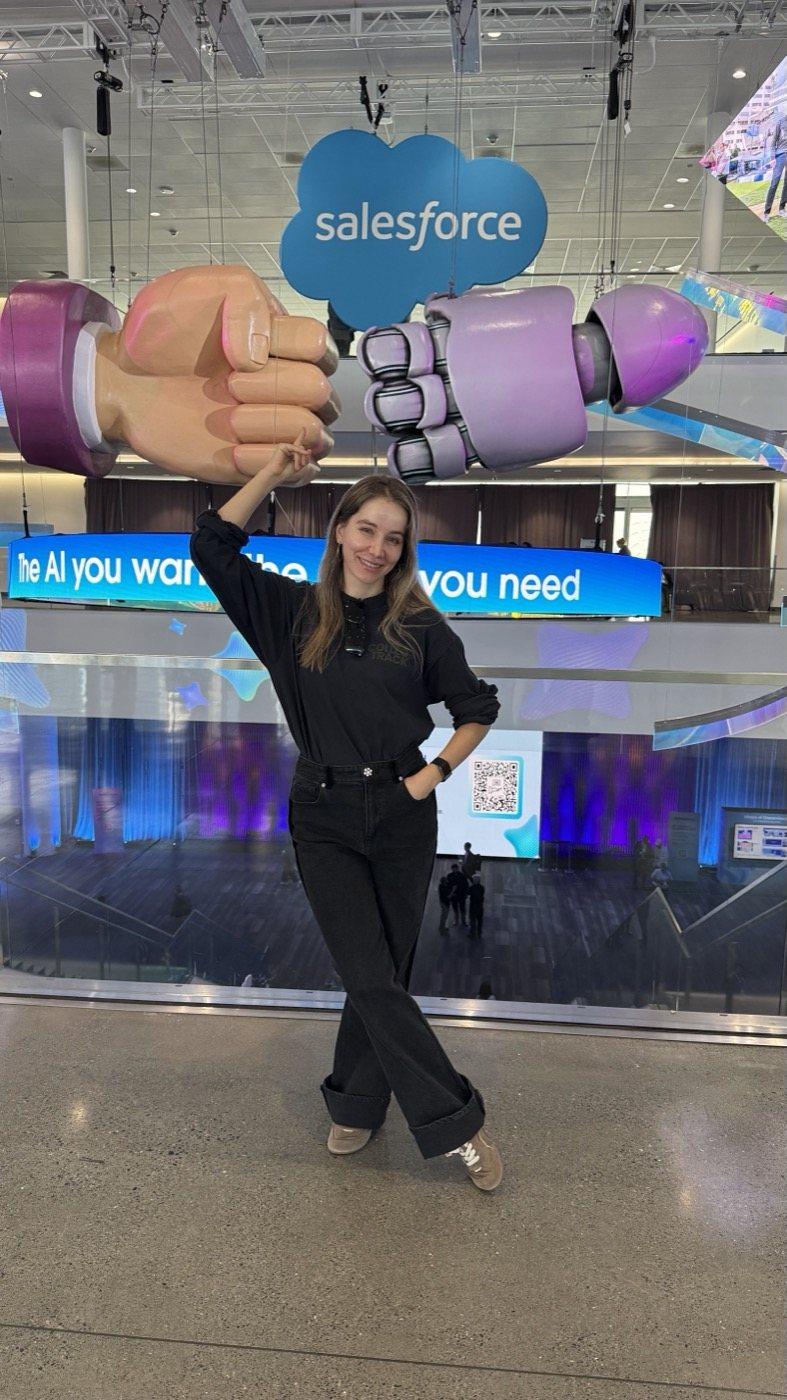Anne Becheru stands under the fist bump sculpture on the Dreamforce site.
