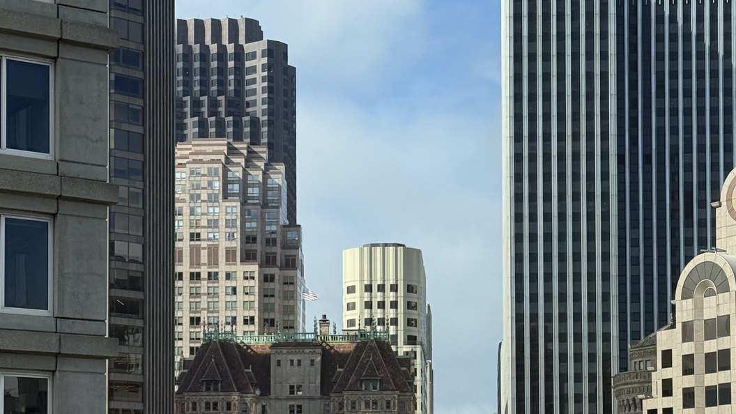 Downtown San Francisco seen from a high window, glass and stone towers stacked against a clear sky